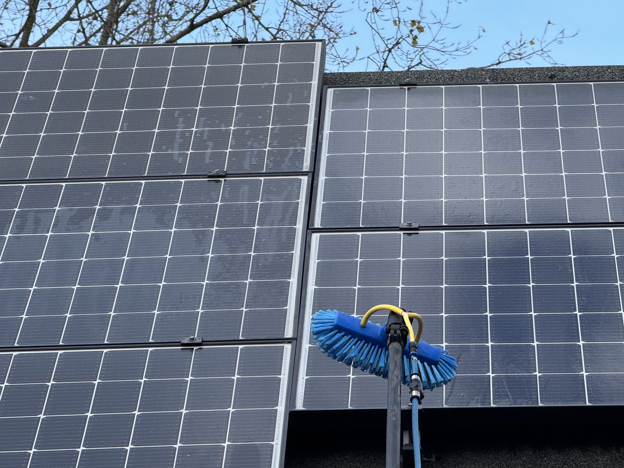 Borstel op een lange paal tegen zonnepanelen